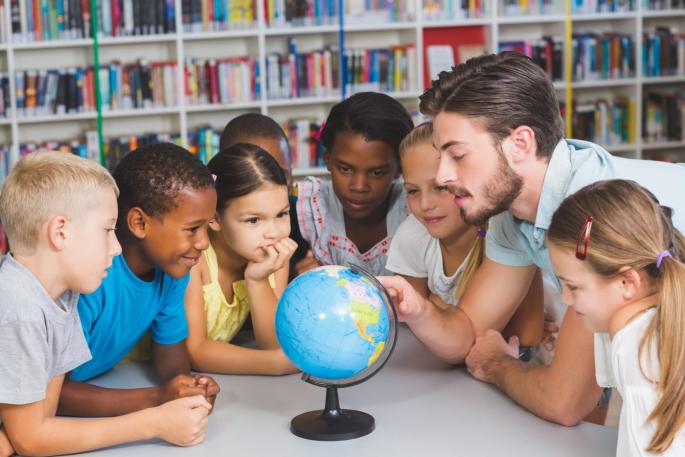 Symbolbild: Lehrperson mit Globus und Kindern