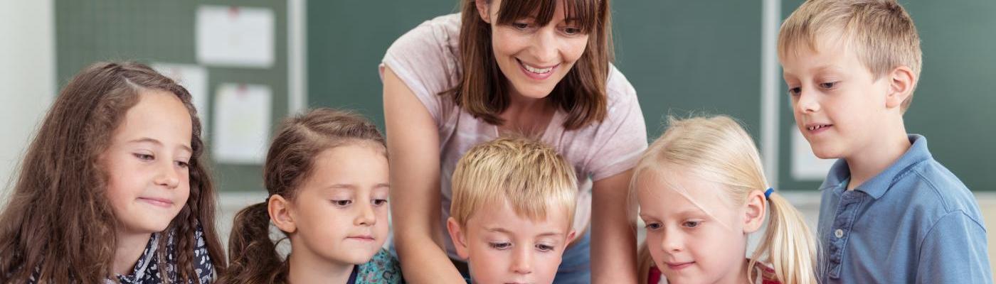 Lehrerin mit Kindern und einem Tablet