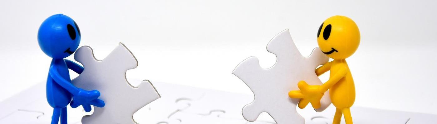 Symbolbild zwei Männchen mit Puzzleteilen